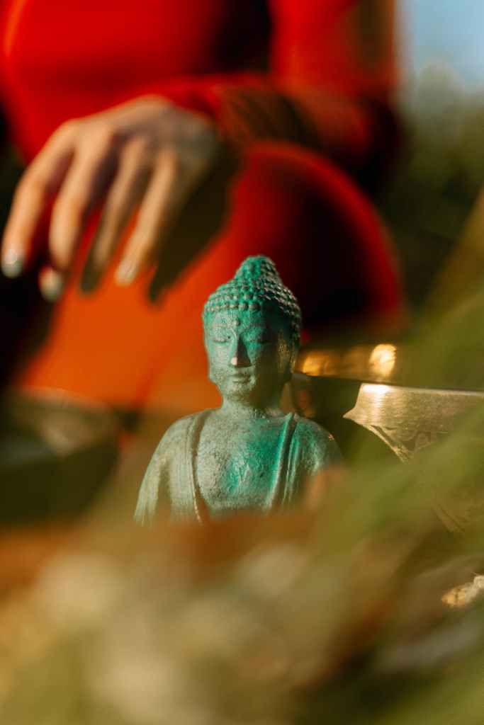 close up of a copper buddha statue at the feet of a tibetan monk